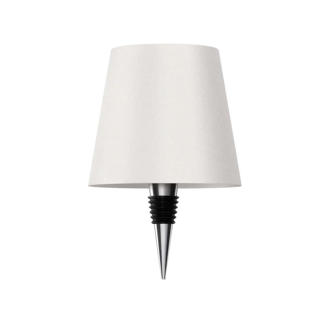 Eclectic Essentials AuraLite wireless rechargeable bottle lamp in transparent white, illuminated and glowing in a stylish setting.